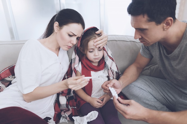 Man en vrouw geven om een dochter met verkoudheid.