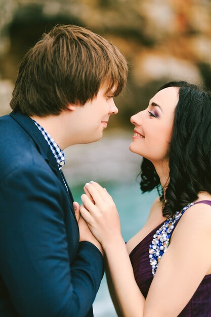 Man en vrouw glimlachen naar elkaar, hand in hand close-up