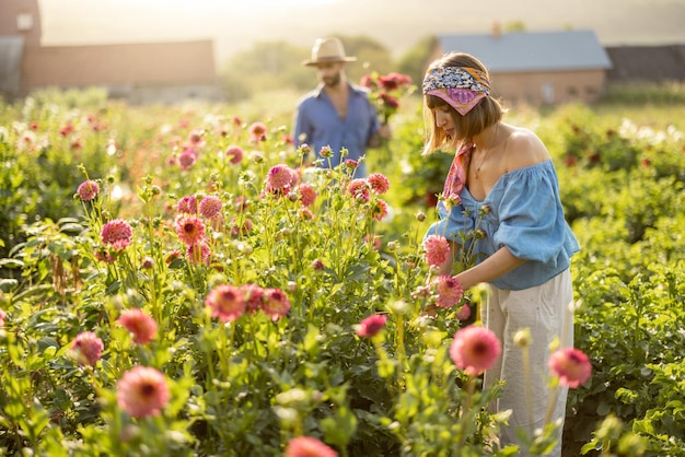 Man en vrouw halen bloemen buiten op de boerderij