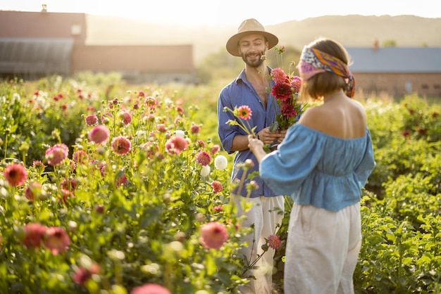 Man en vrouw halen bloemen buiten op de boerderij