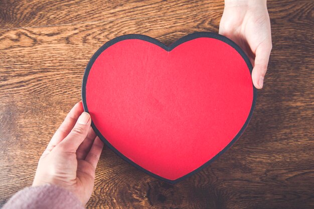 Man en vrouw hand met geschenkdoos hart