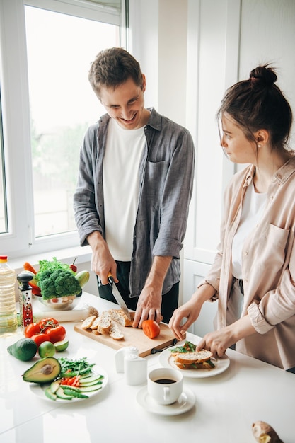 Man en vrouw hebben samen plezier in de keuken terwijl ze ontbijt maken, een gezonde maaltijd, familiekok...