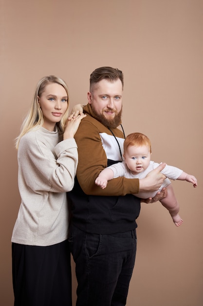 Man en vrouw houden een baby in hun armen. Portret van een echtpaar na de geboorte van een kind. Jong gezin