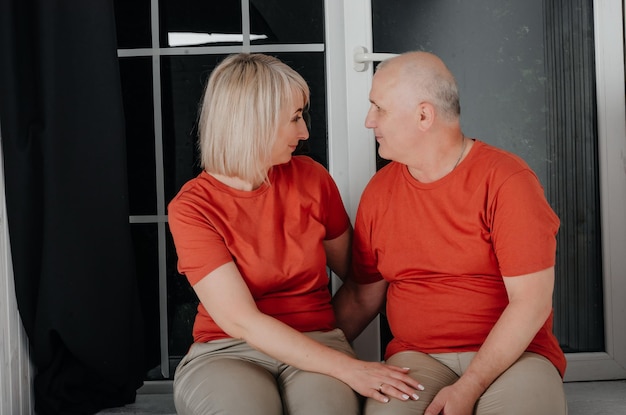 man en vrouw in oranje t-shirts knuffel en kus