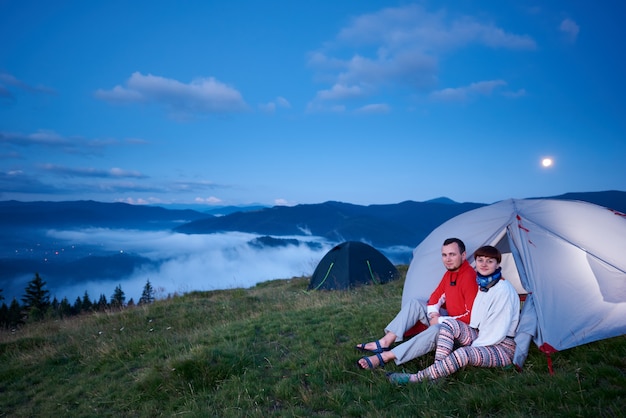 Man en vrouw in tent bij zonsopgang