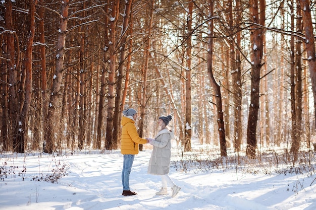 Man en vrouw in warme kleren in winterbos buitenshuis