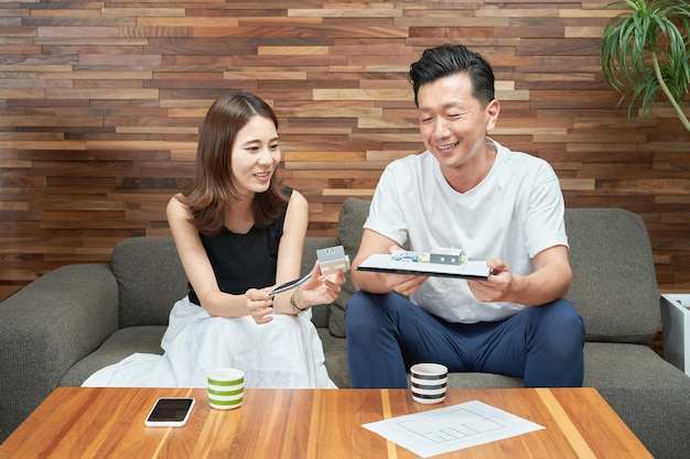 Man en vrouw kijken naar een model van een huis