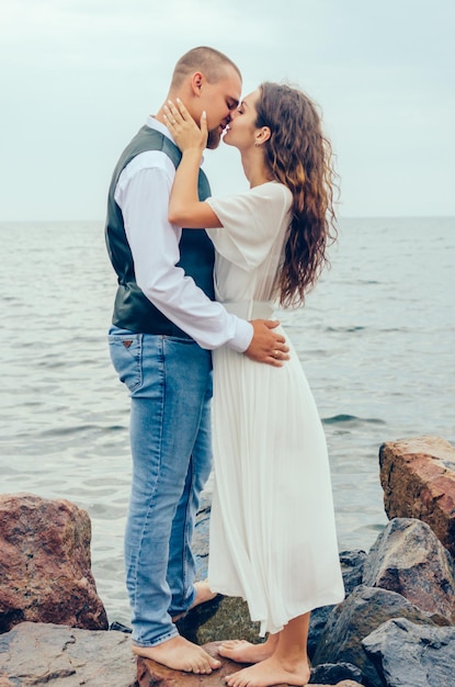 man en vrouw knuffelen staande op de rotsen bij de zee Huwelijksreis