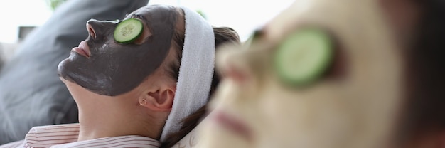 Man en vrouw liggen op de bank met een verjongend masker op hun gezicht