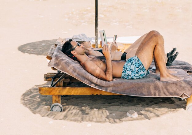 Foto man en vrouw liggen op het strand.