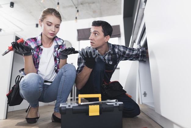 Man en vrouw loodgieter reparatie wastafel in keuken in keuken.