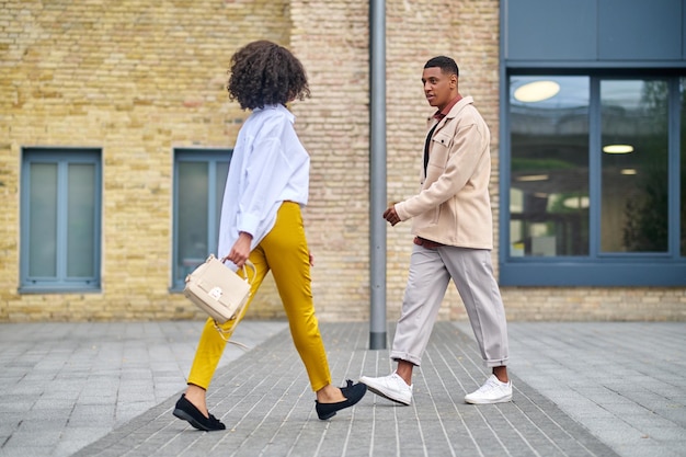 Foto man en vrouw lopen naar elkaar toe op straat