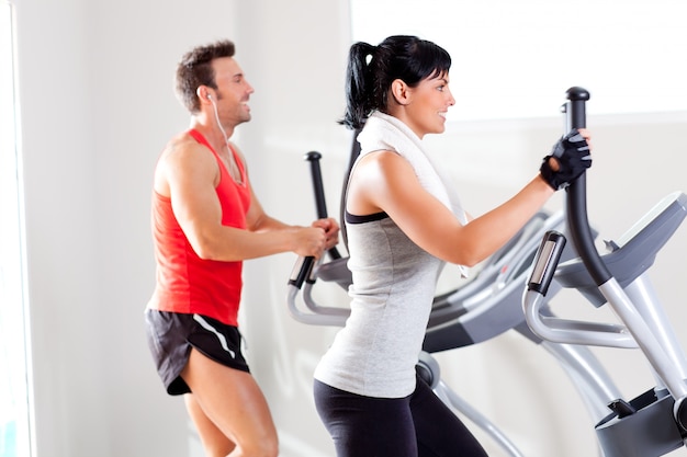 man en vrouw met crosstrainer op de sportschool