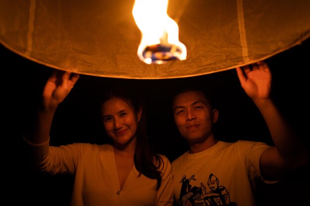 Foto man en vrouw met een papieren lantaarn tijdens het yi peng festival chiang mai thailand