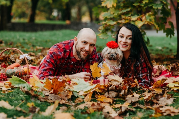 Man en vrouw met hond liggen op een deken in de herfstbladeren