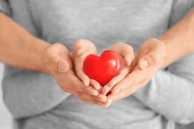 Man en vrouw met klein rood hart in hun handen