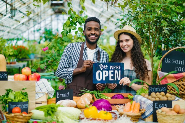 Man en vrouw met open bord aan tafel met biologisch voedsel op de markt
