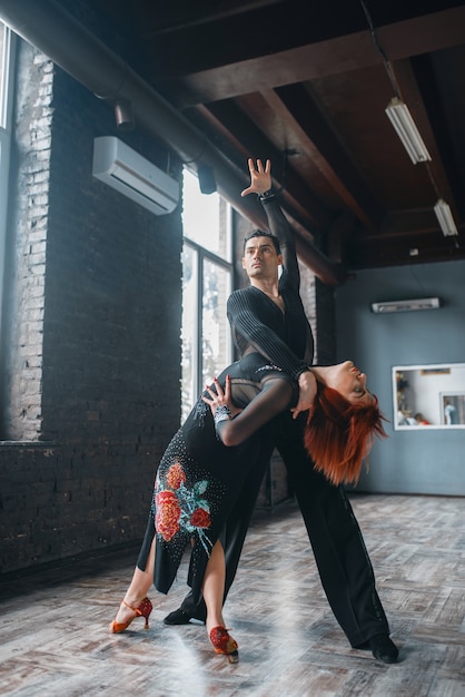 Man en vrouw op ballrom-danstraining in de klas. Vrouwelijke en mannelijke partners op professioneel paar dansen in studio