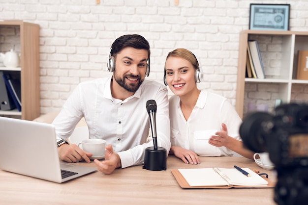 Man en vrouw-podcasters interviewen elkaar.