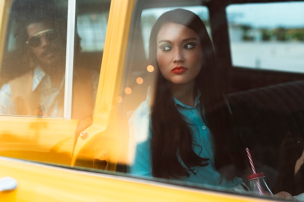 Foto man en vrouw poseren in retro stijl met auto