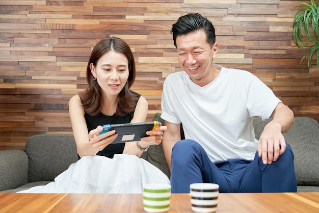 Man en vrouw spelen met draagbare spelcomputer