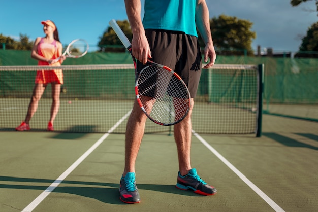 Man en vrouw tennissen in de open lucht.