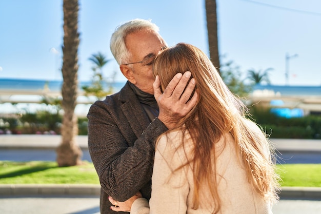 Man en vrouw van middelbare leeftijd die elkaar omhelzen terwijl ze in het park staan