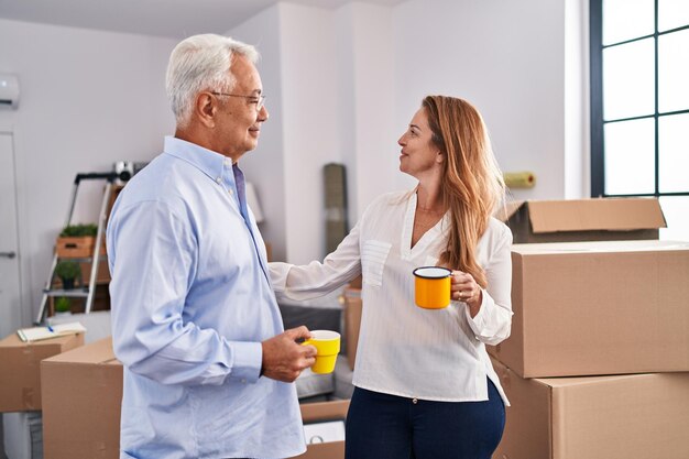 Man en vrouw van middelbare leeftijd die koffie drinken in een nieuw huis