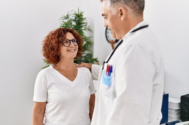 Man en vrouw van middelbare leeftijd in doktersuniform met medisch consult in de kliniek