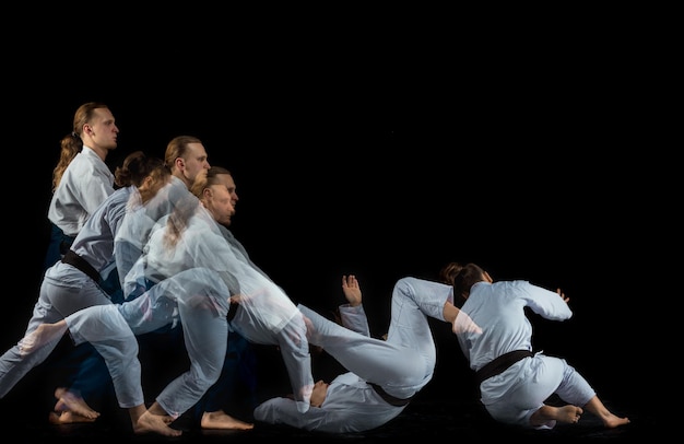 Man en vrouw vechten en trainen aikido op zwarte studio achtergrond