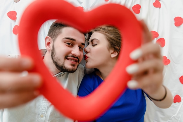 Man en vrouw verliefd in bed met hartvormen
