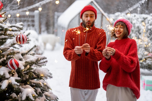 Man en vrouw vieren nieuwjaarsvakantie met sterretjes buitenshuis