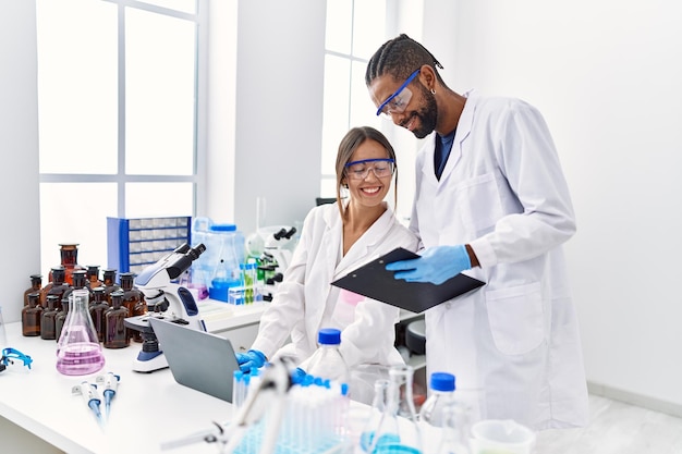 Man en vrouw wetenschapper partners glimlachen zelfverzekerd werken in het laboratorium