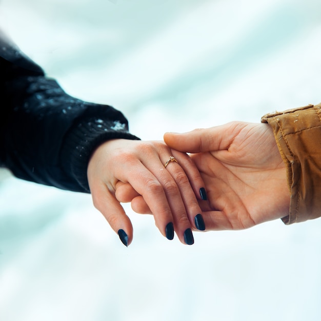 Man en vrouw zijn verloofd en houden elkaars hand vast.