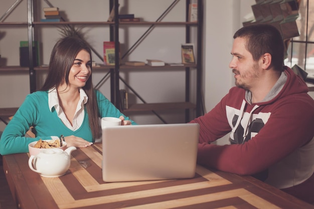 Man en vrouw zitten aan tafel en kletsen