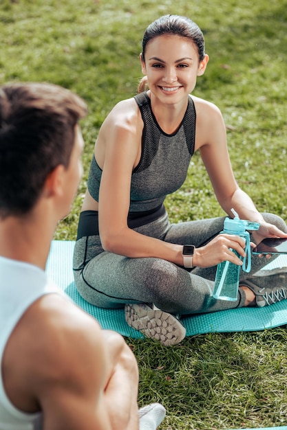 Man en vrouw zitten in het park na het sporten