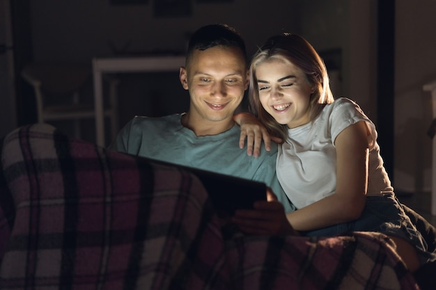 Man en vrouw zitten 's avonds thuis