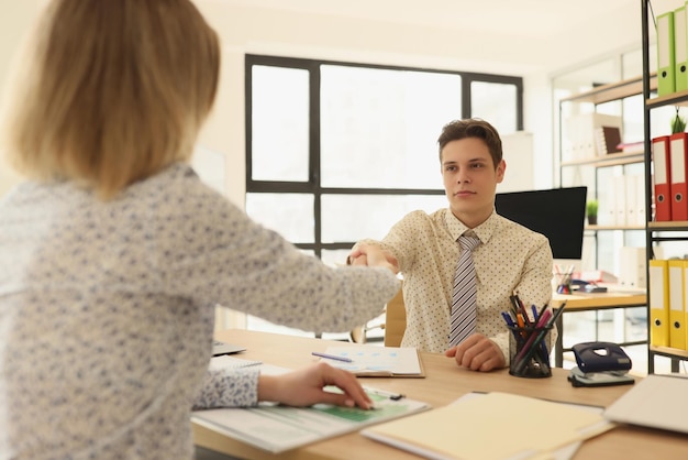 Man en vrouwenmanagershandenschudden in bureauconcept samenwerking en overeenkomst