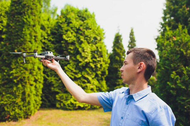 Foto man en zijn drone quadrocopter in een bos op een groene achtergrond