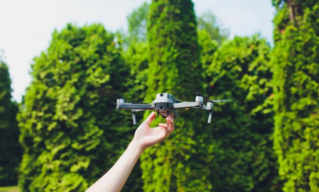 man en zijn drone quadrocopter in een bos op een groene achtergrond