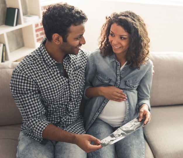 Man en zijn mooie zwangere vrouw kijken naar sonogram