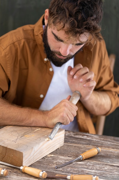 Photo man engraving in wood outdoors