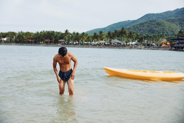 Photo man enjoying kayaking adventure on a tropical beach