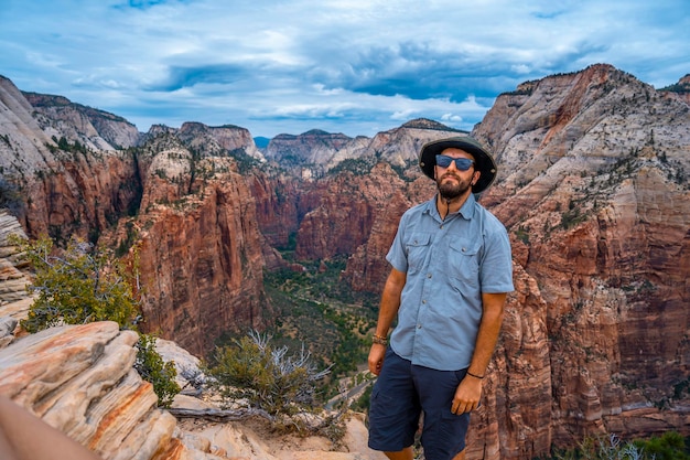 Photo a man enjoying the views of zion from the angels landing trail in zion national park