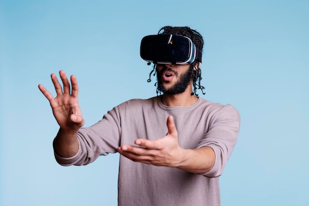 Man enjoying virtual reality leisure activity and exploring cyberspace in vr glasses. Young adult person in headset experiencing simulation and playing video game in metaverse