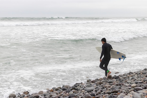 Man entering the water to surf