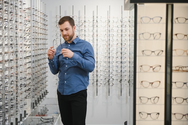 Photo man evaluating quality of glasses in optical shop