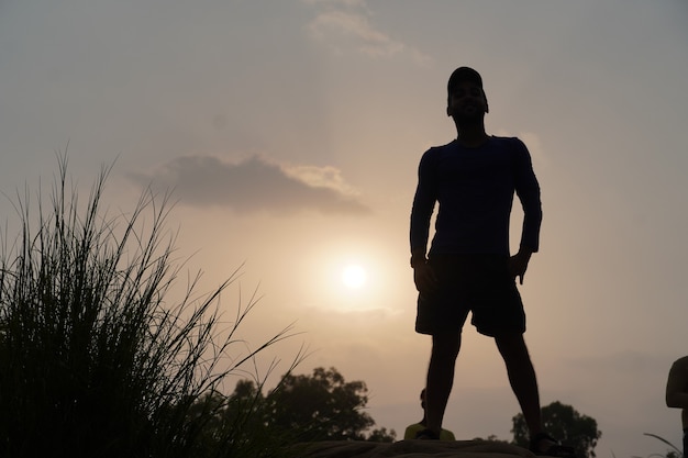 太陽の近くに立っている夕方の男