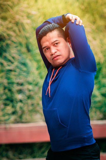 Man exercising against trees in park