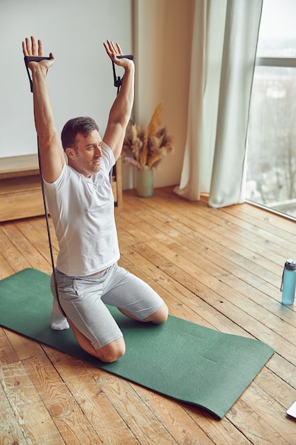 Man exercising during online video workout from home